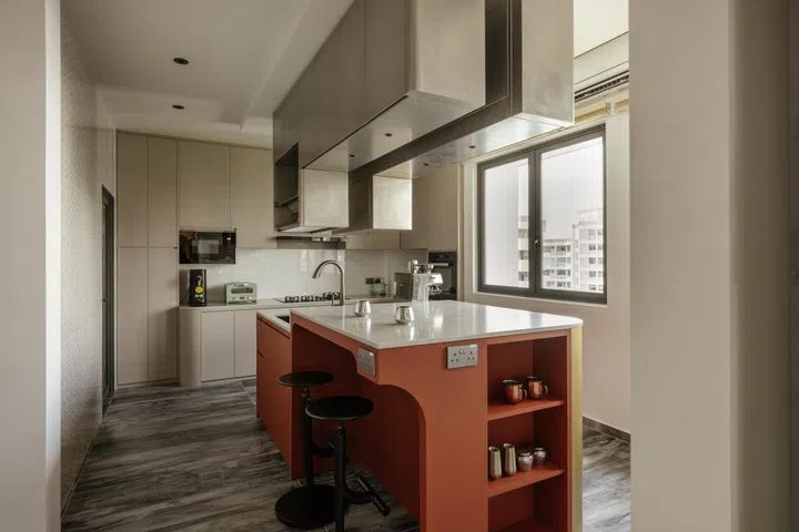 Double upper cabinets extend the axis into the kitchen, forming a softly lit spine that organises the space.