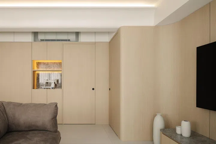 Full-height storage line the living room in a 4-room HDB in Punggol.