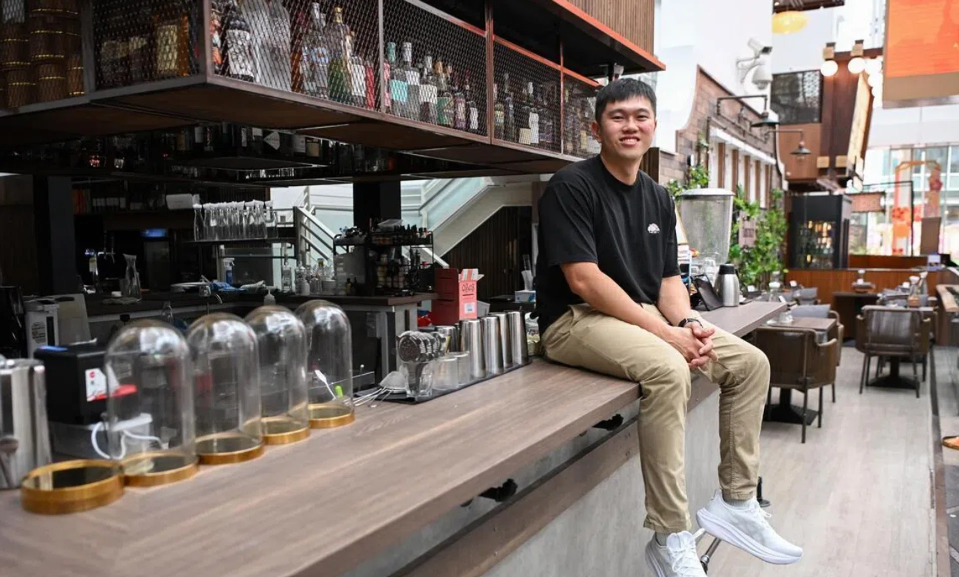 Hopscotch co-founder Roger Yip atop the bar counter he built himself, along with tabletops, design features and lighting.