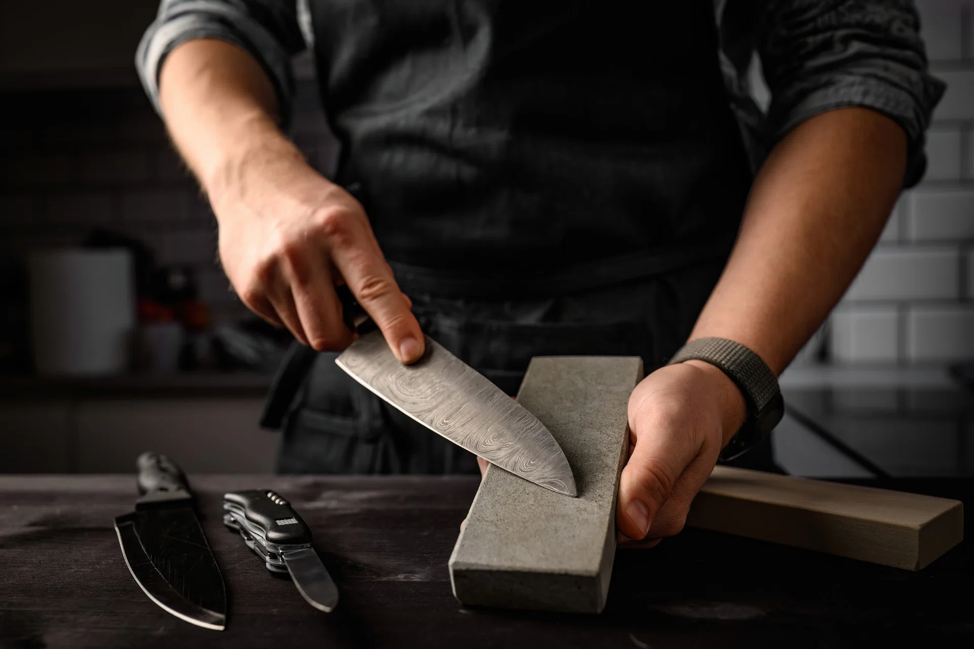 Man sharpening a knife with sharpen stone tool. 