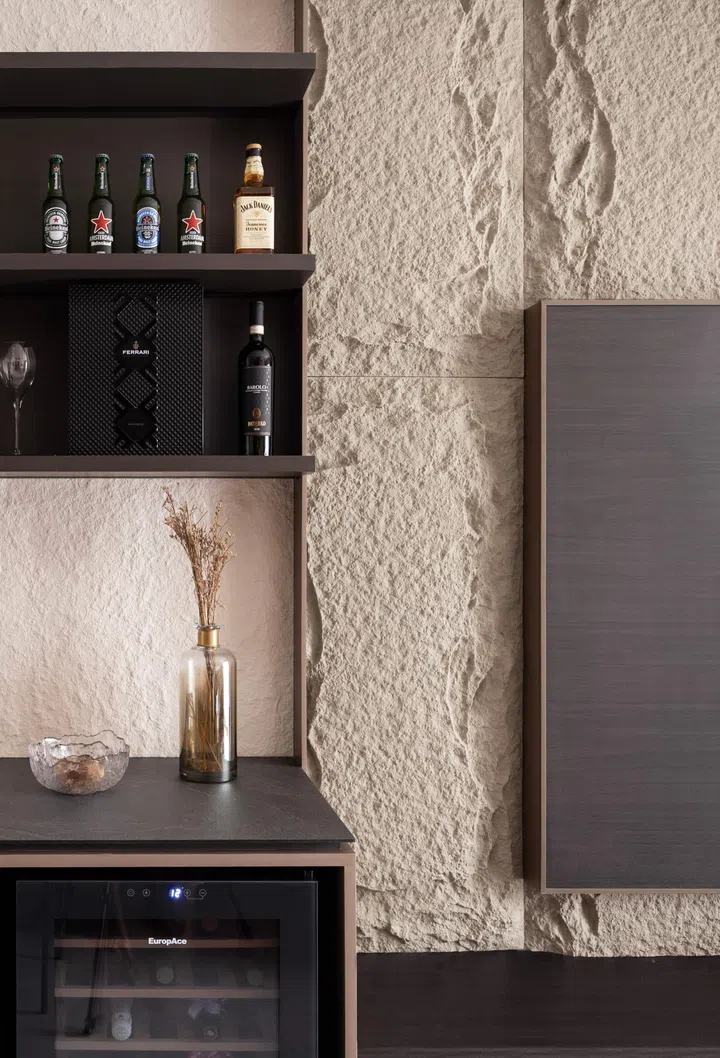 Above the wine fridge are shelves displaying the drinks collection.
