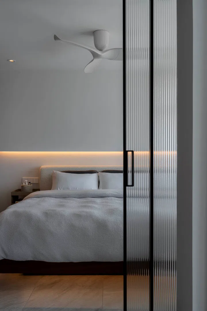 Concealed panels open to reveal the master suite, maintaining the home’s minimalist lines.