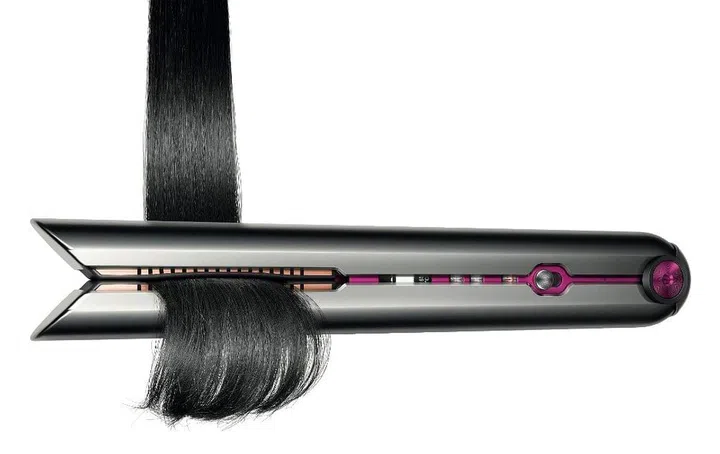 Dyson Corrale Hair Straightener clamping a bundle of black straight hair.