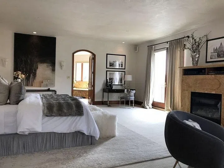 Eva Longoria's Hollywood Dell mansion's master bedroom is accented with a cosy fireplace, along with two walk-in closets and a spacious tiled bathroom.