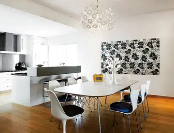 Organic shapes and straight lines meet in this mix of mid-century pieces and modern build-in furniture, pulled together with a clean white palette.
