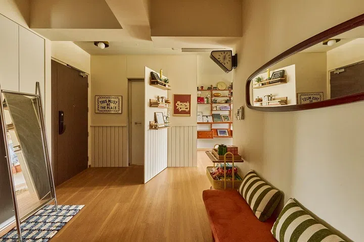 Floating shelves and clean-lined panelling transform an ordinary wall into a striking feature that quietly conceals a door.