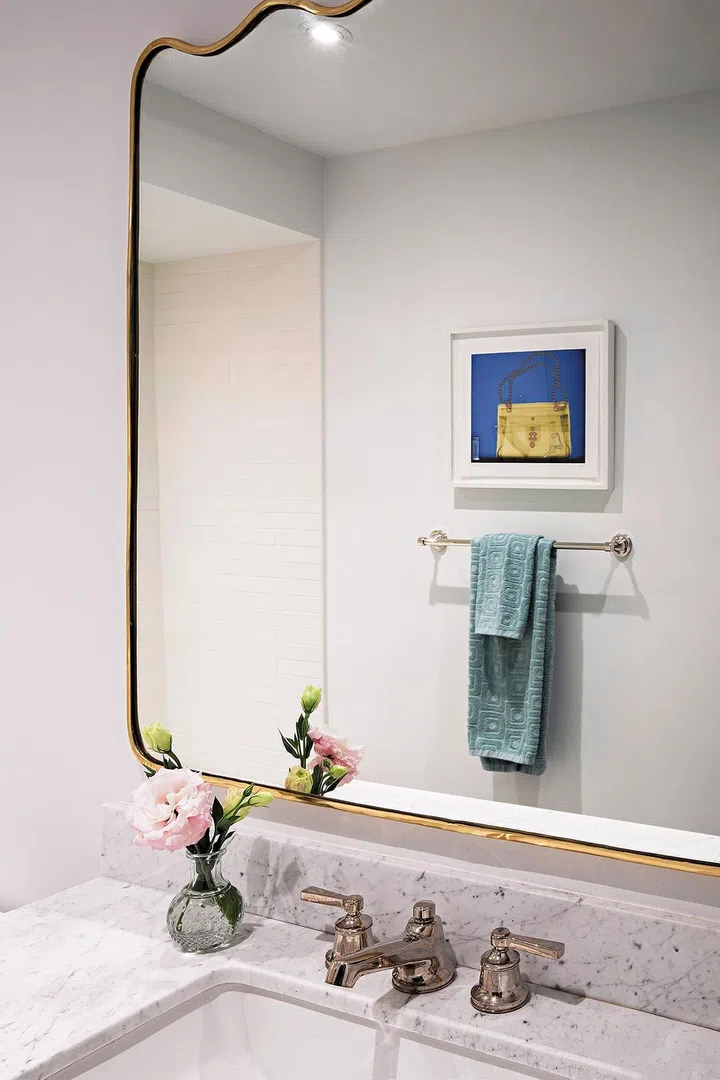 The curved edges of the mirror softens the look in the bathroom.