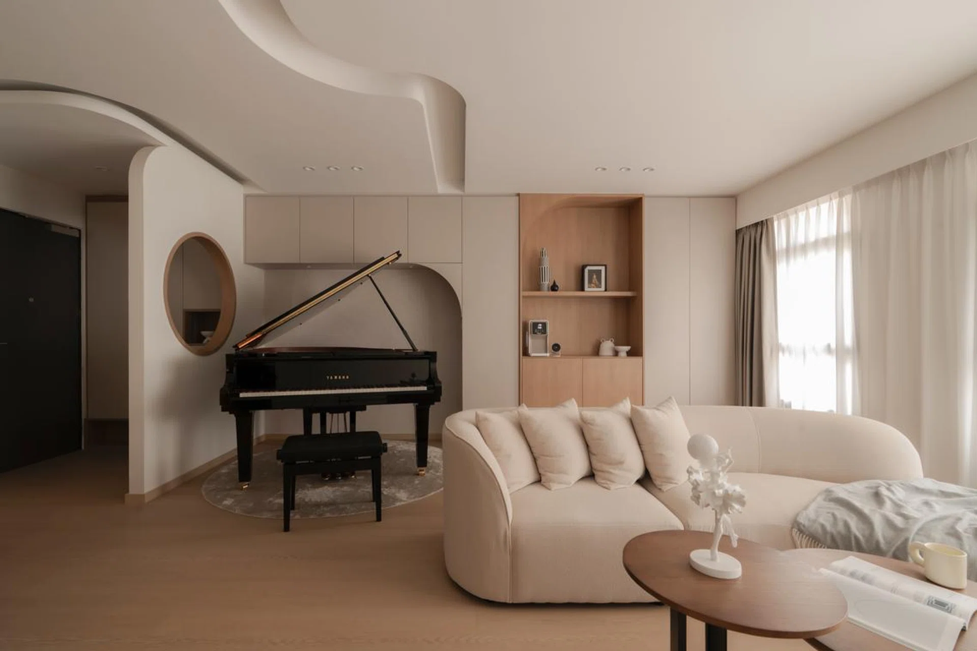 Natural light washes over the sculpted ceiling and piano alcove, where gentle curves frame a grand piano at the heart of the home.