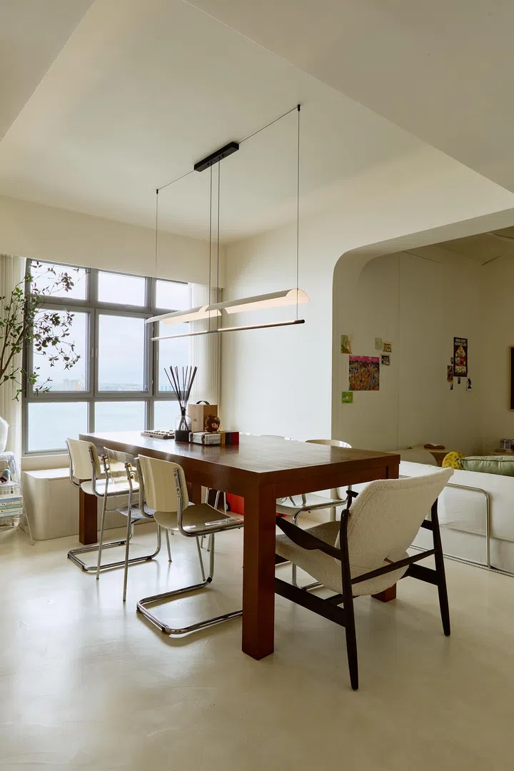 Positioned to face the horizon, the dining table captures uninterrupted sea views when the shades are raised, turning daily routines into a quiet ritual.