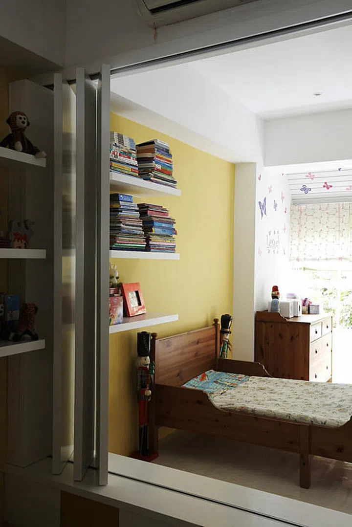 Butterfly decals and a soft yellow feature wall cheer up the room to warm even the farthest corners.