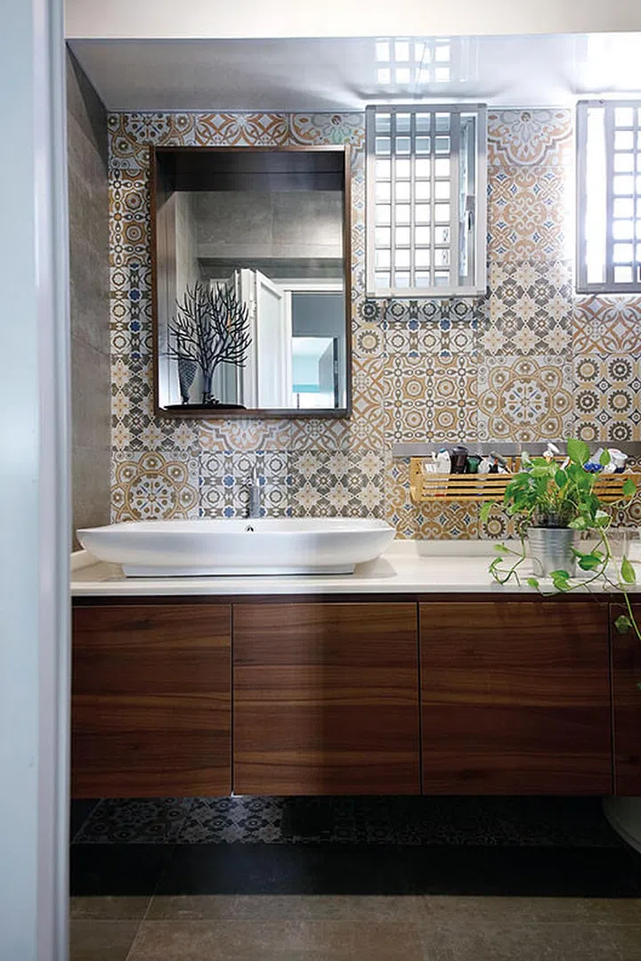 A more soothing palette was adopted for the common bathroom, which features tiles with Peranakan- inspired motifs.