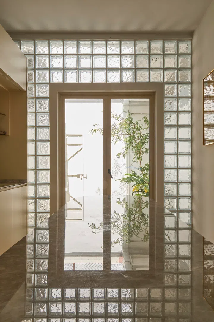 Glass blocks filter daylight into the kitchen, diffusing light softly across surfaces throughout the day.