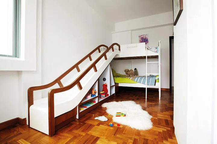 A kids loft bed with a slide and storage under. Interior design by Lekker Design