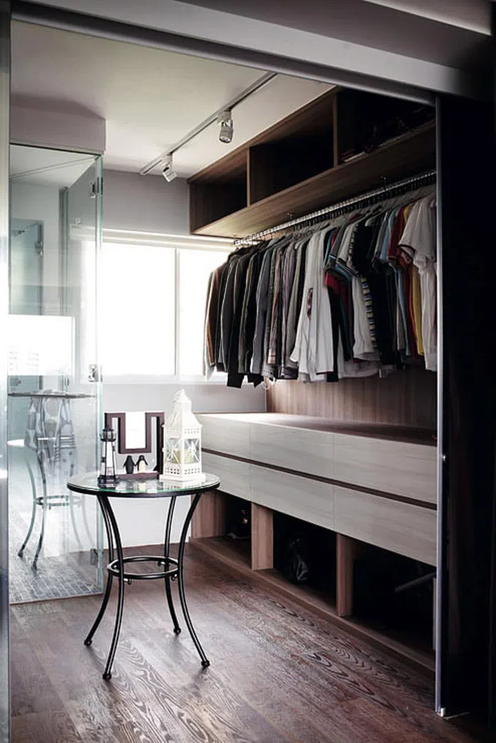 The end of the walk-in features a glass-walled bathroom vanity that leads to the shower and WC.
