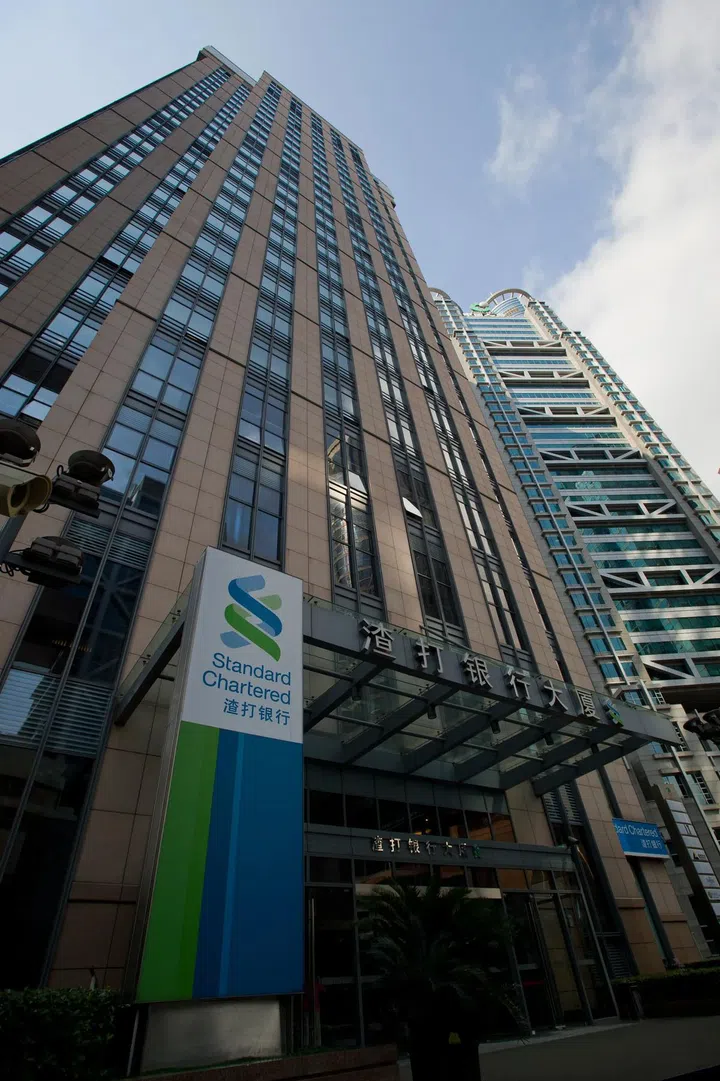 Shanghai Lujiazui Finance and Trade Zone of the modern city featuring a Standard Chartered Bank logo in the foreground at the entrance. Photo 123RF