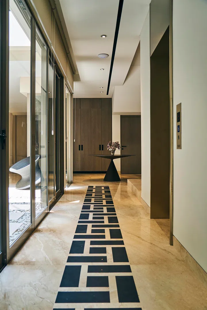  A patterned stone inlay draws the eye through the corridor, linking the courtyard with the main living areas.