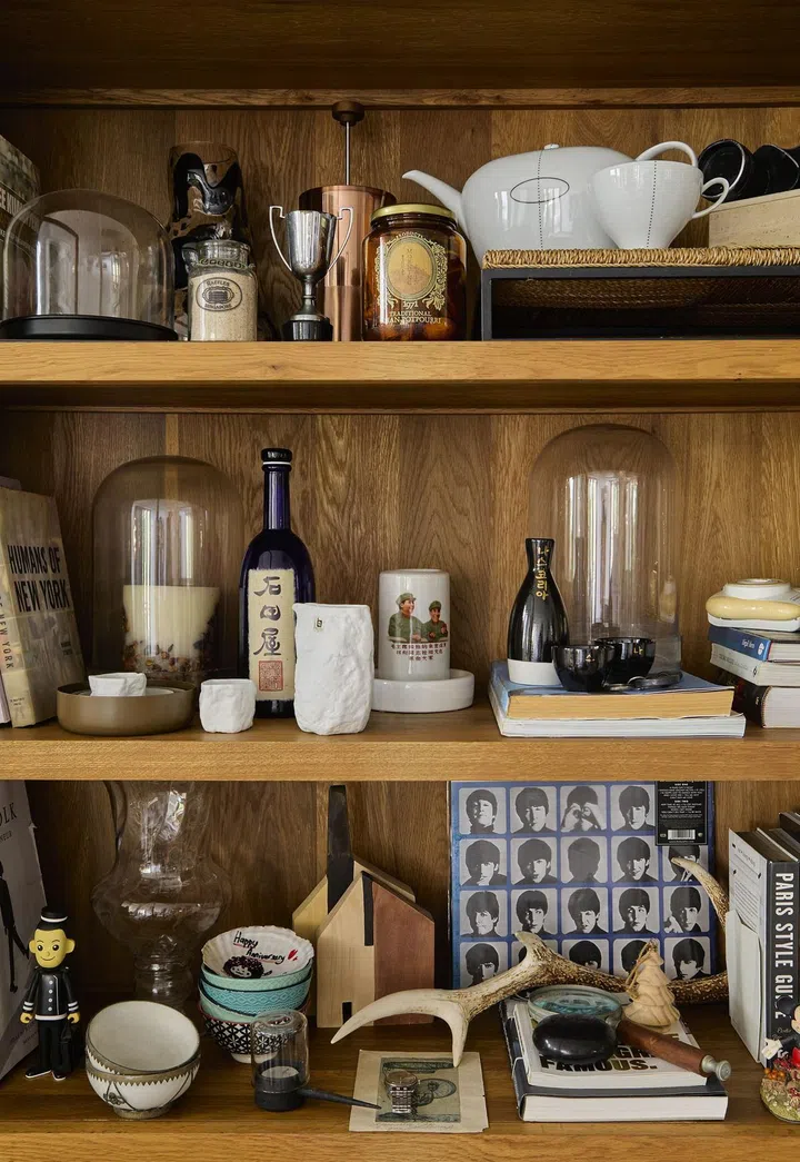 A collection of the homeowner's travel souvenirs displayed on an open shelf in this 1,080 sq ft 2-bedroom Bayshore Park condo.