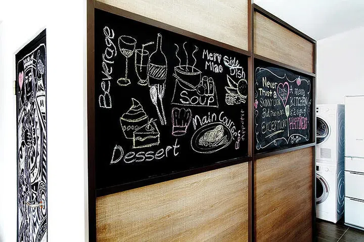 Chalkboard wall sliding door conceals the bomb shelter in this HDB flat.