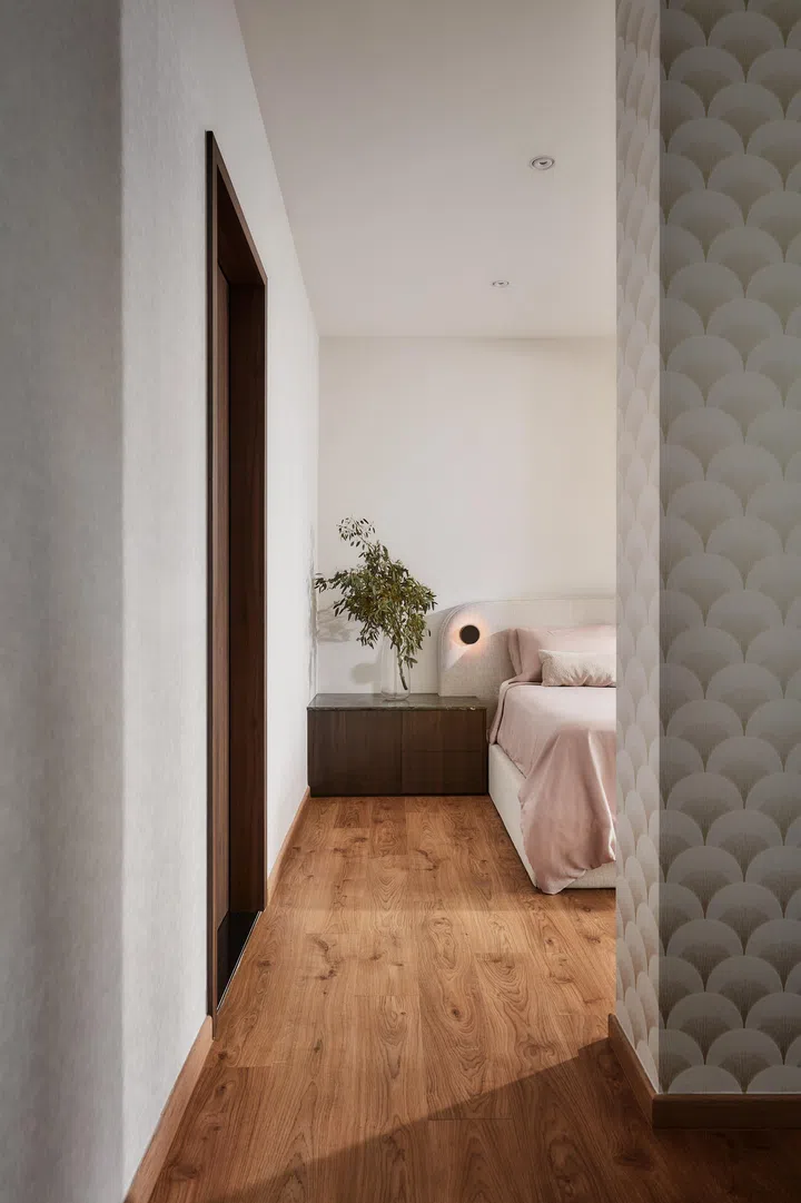 Light tones, soft textures and warm timber define the master suite, creating a gentle counterpart to the home’s sculptural communal spaces.