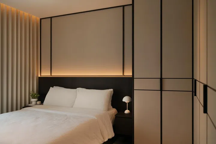 Without a television or unnecessary decoration, the bedroom relies on carefully proportioned carpentry, limewashed walls and soft lighting to create a calm retreat.