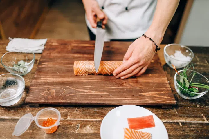 Male person cooking seafood, japanese food