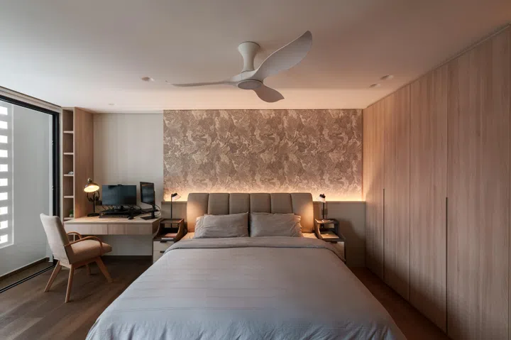 Warm timber tones, concealed storage, and soft lighting give the primary bedroom a calm, retreat-like atmosphere.
