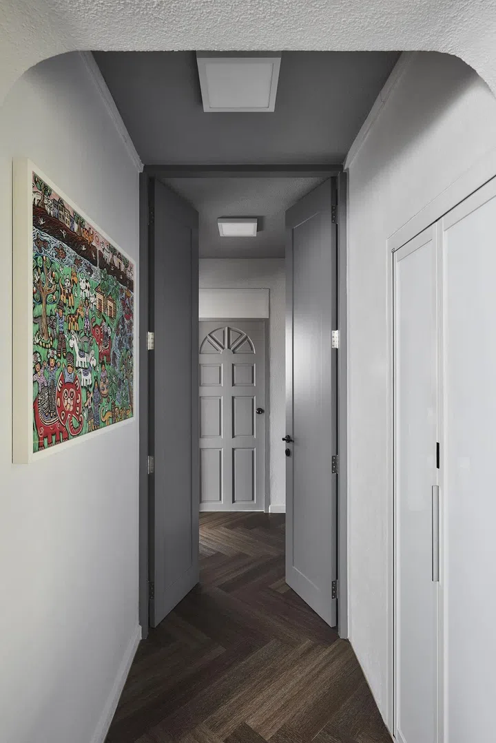 Grey doors adorn the walkway into the master bedroom in this 1,650 sq ft 3-bedroom Marine Parade condo.
