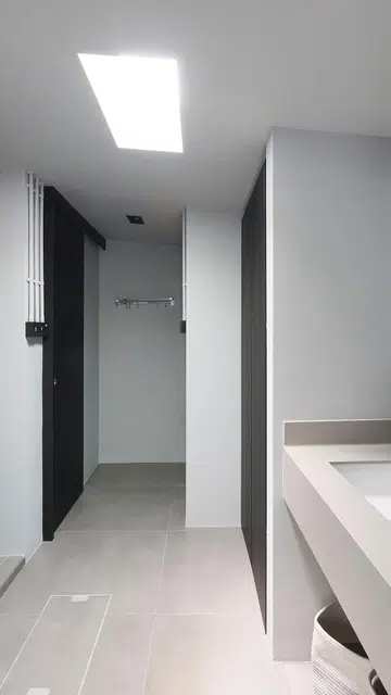 Skylight in the monochrome bathroom of this 1,189 sq ft single-storey corner terrace house in Siglap.