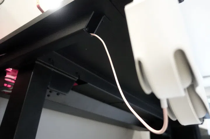 A white, one single cable running from the leg of the Secretlab Magnus Pro metal desk. Photo from Hardwarezone