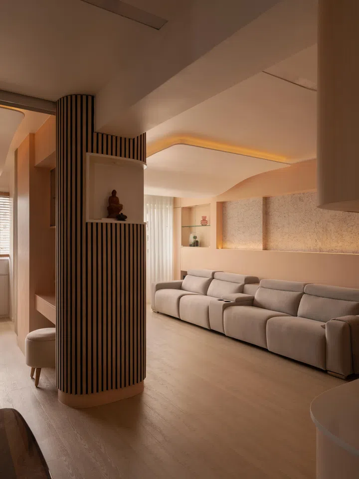 Integrated joinery lines the living room, with recessed niches and flush panels keeping storage and display contained within the architectural envelope.