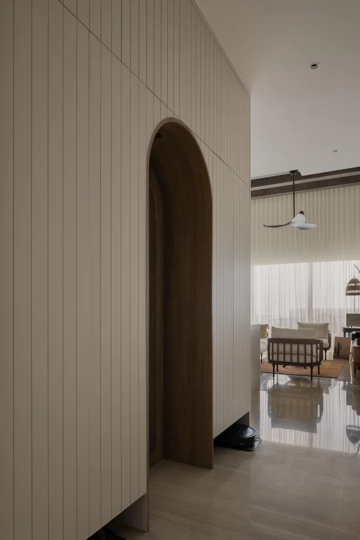 The condo’s foyer boasts an arched design, lending geometry to the home’s first point of entry. The archway itself is a mirror for an outfit check. Within is a stool and shoe storage. 