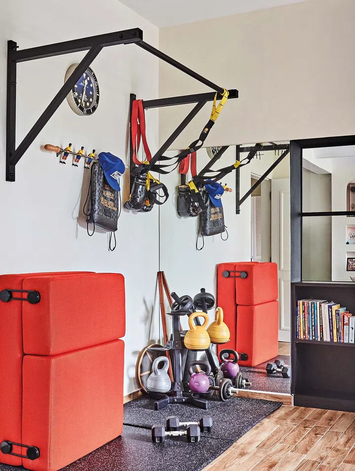 A corner of Dennis’ home office is dedicated to his gym equipment. An oversized mirror panel makes it appear more spacious.