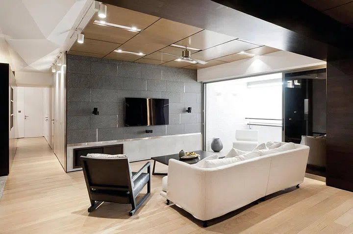 Timber panels framed with black aluminium strips create depth and visual interest to distract viewers from the low ceiling.