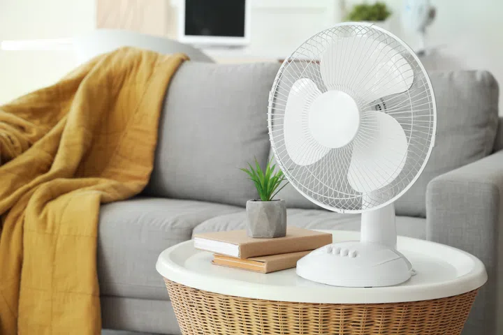 Modern electric fan on coffee table in living room, closeup