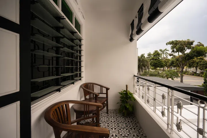 Black-and-white bamboo blinds and dark wood furniture channel the classic colonial bungalow vibe.