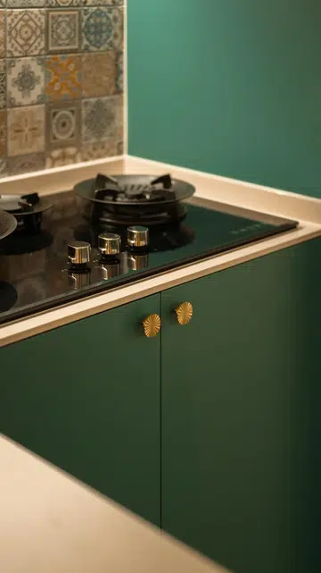 Brass hardware and rich green cabinetry add warmth and character without overwhelming the bold Moroccan-inspired palette.