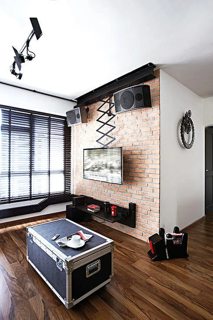 Classic red bricks form a trendy accent wall that helps conceal unsightly cables as well! Interior design by Space Sense