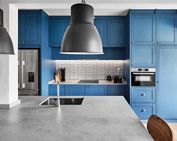 Large pendant lights help to direct illumination across the kitchen counter, creating a cosy look.