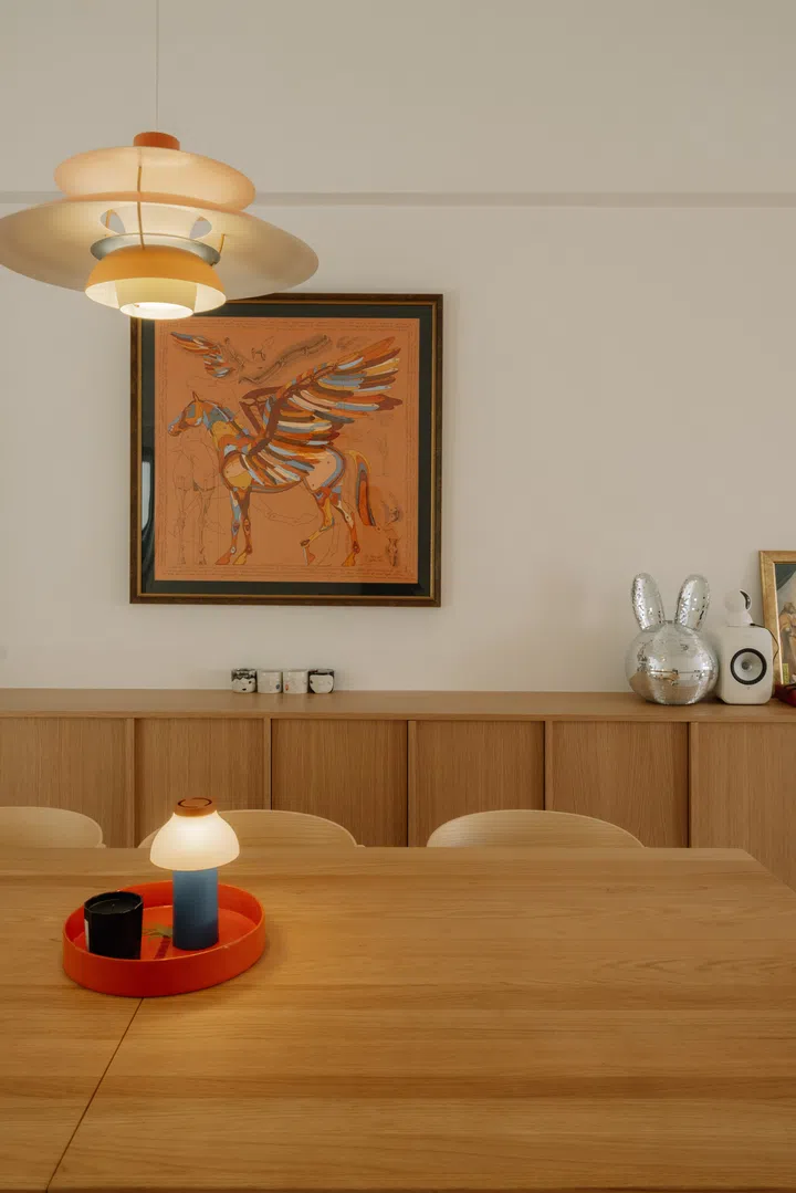 A framed Hermès Pegasus scarf provides a colourful focal point above the bespoke oak cabinetry, balancing the warmth of the oak with a playful dose of personality.