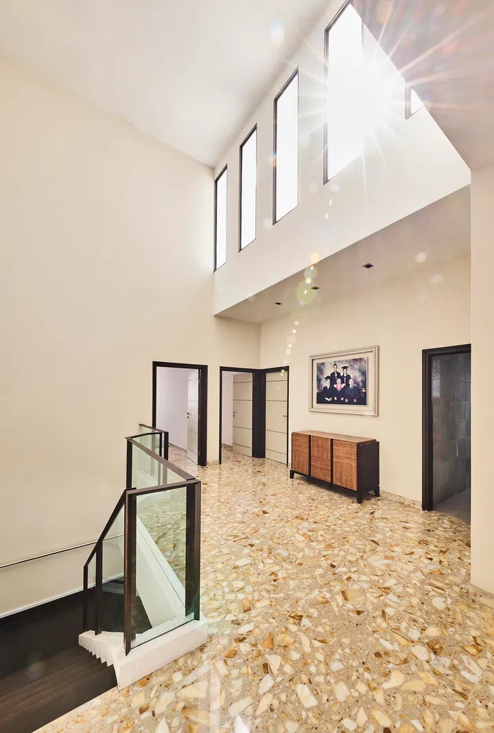 Large format windows allow plenty natural sunlight into the second floor of the semi-detached house. Family portraits anchor the interiors.