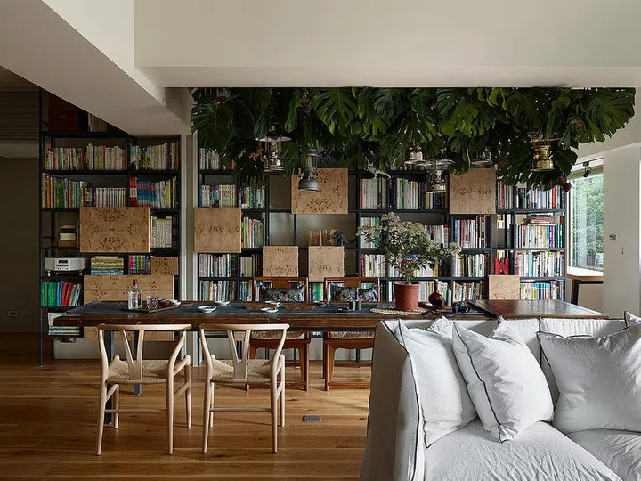 A wall divides the dining area and bedroom, but it is concealed behind this large bookcase -- which is a much prettier! Design: Ganna Studio