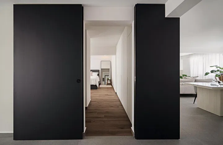 Navy blue, floor-to-ceiling sliding door that leads to the master bedroom