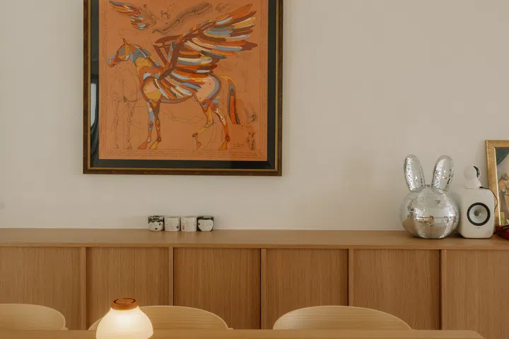 A framed Hermès Pegasus scarf provides a colourful focal point above the bespoke oak cabinetry, balancing the warmth of the oak with a playful dose of personality.