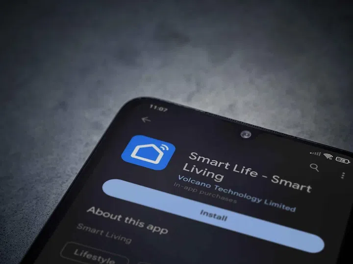 Smart Life app play store page on smartphone on a dark marble stone background. Top view flat lay with copy space.
