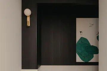 A dark timber-lined ceiling gently lowers over the entry corridor, guiding the eye forward before opening out into the living and dining area of a 3-bedroom (1,098 sq ft) condo in Penrose.