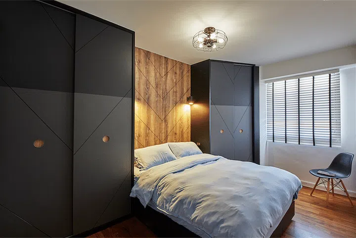 A timber headboard is flanked by two black wardrobes positioned at odd angles for a unique look. Design: Ju Design Studio