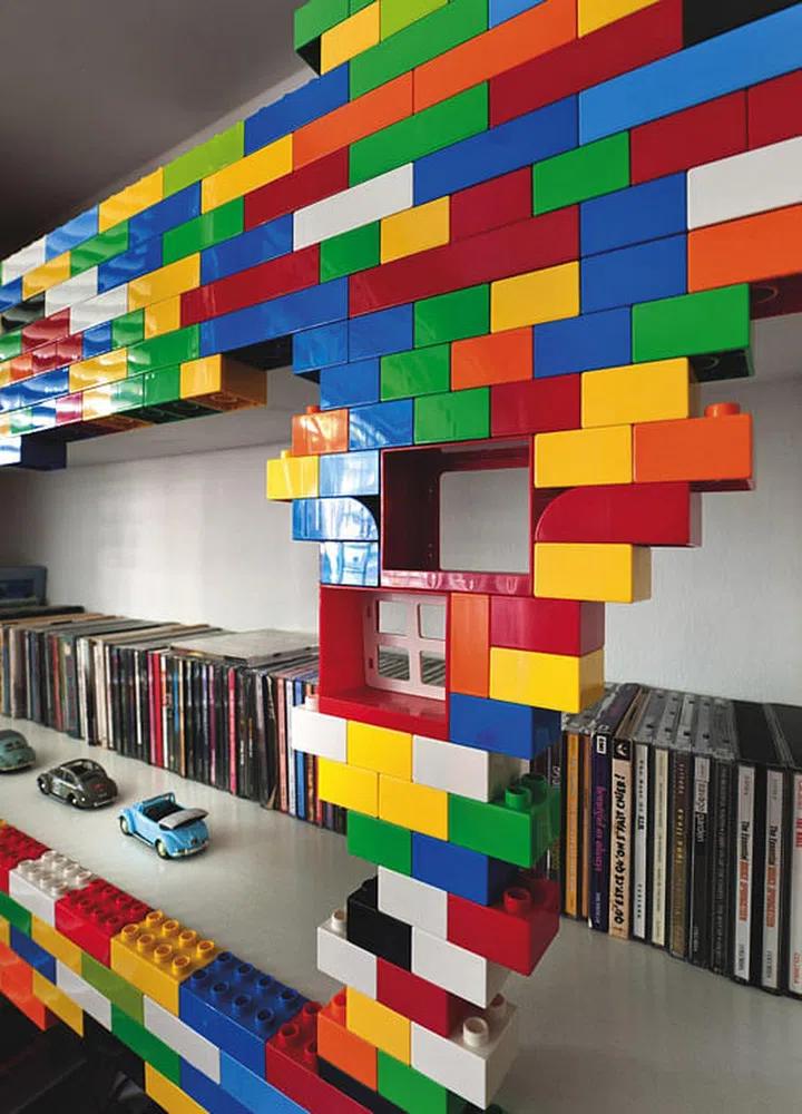 Huge ‘Lego Blocks’ were fixed to wooden bookshelves with 3M tape so the owners could “redesign” the shelves as they prefer.