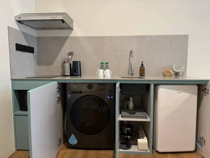 Fully functional kitchenette with a washer dryer machine, bar fridge, and hob. Just like a small condominium.