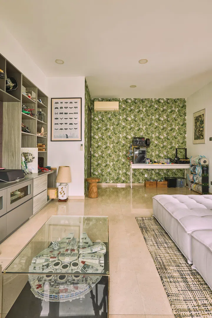 The green, tropical wallpaper is kept to a L-shaped corner by the guest room door.