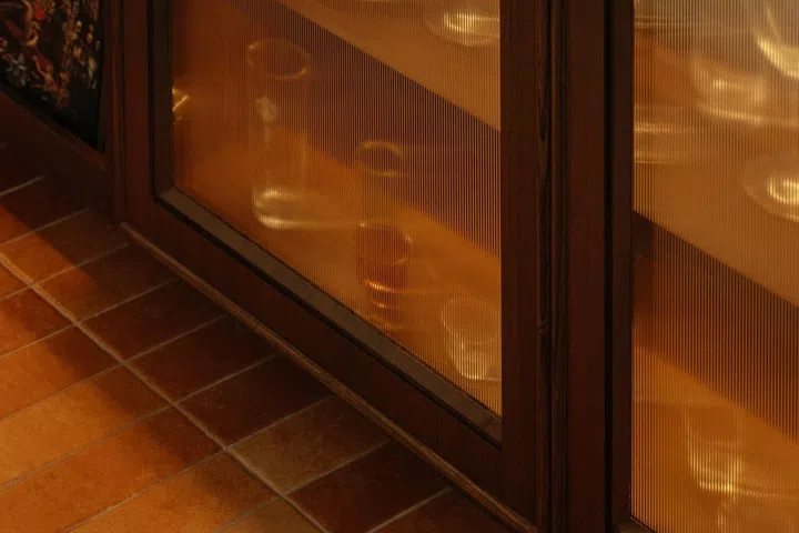 Cafe-like fluted glass cabinet doors and terracotta floor tiles set the mood.